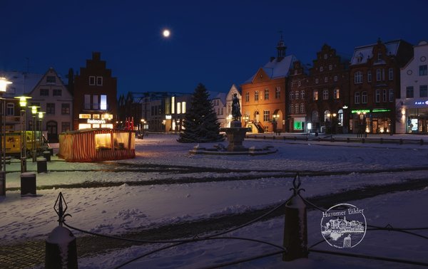 Marktplatz von Husum mit der Tine und Schnee in der Nacht